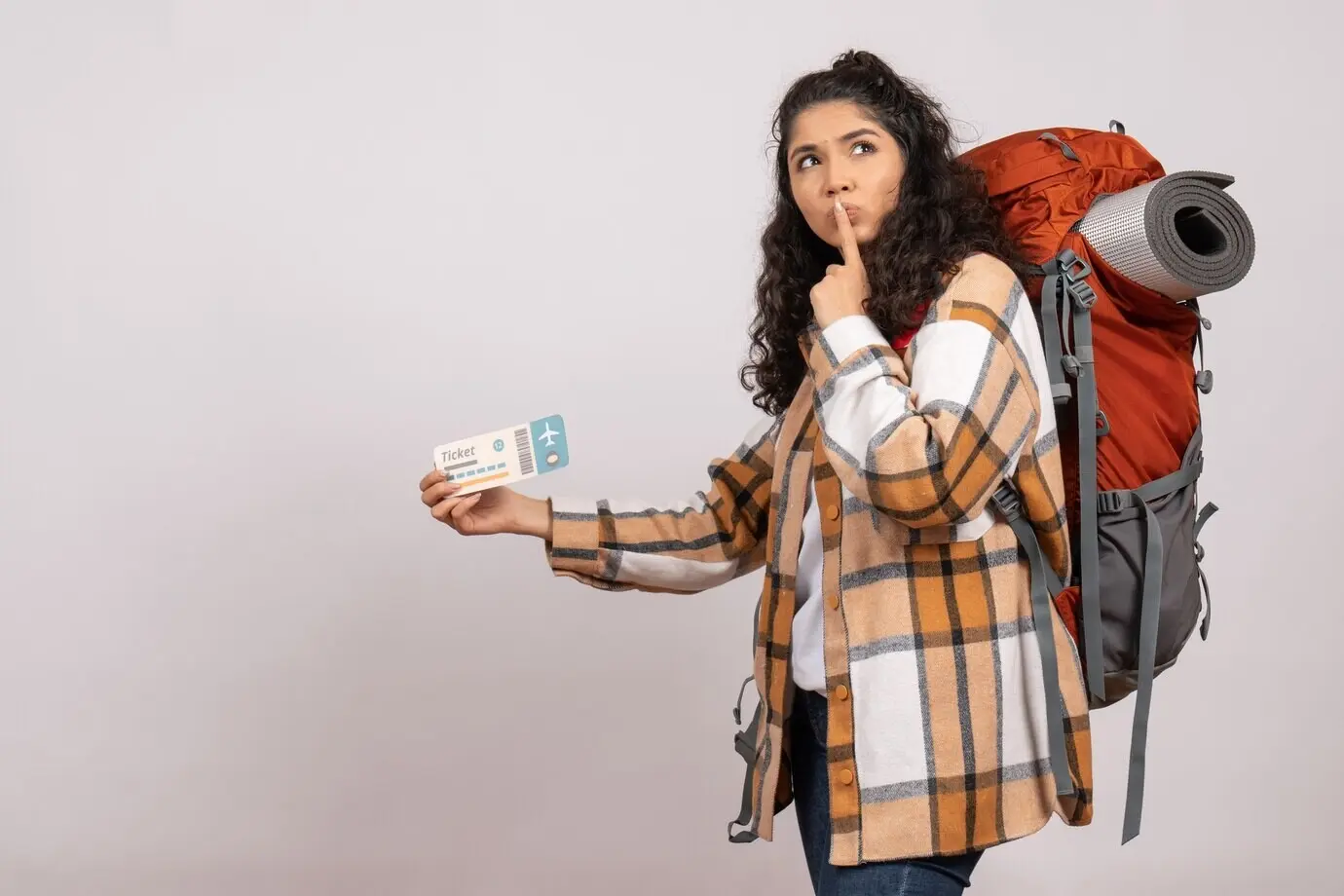 Vorderansicht einer jungen Frau, die wandern geht und ein Ticket hält, vor weißem Hintergrund: Reise, Flug, Touristin, Wald, Urlaub, Campus, Berg.