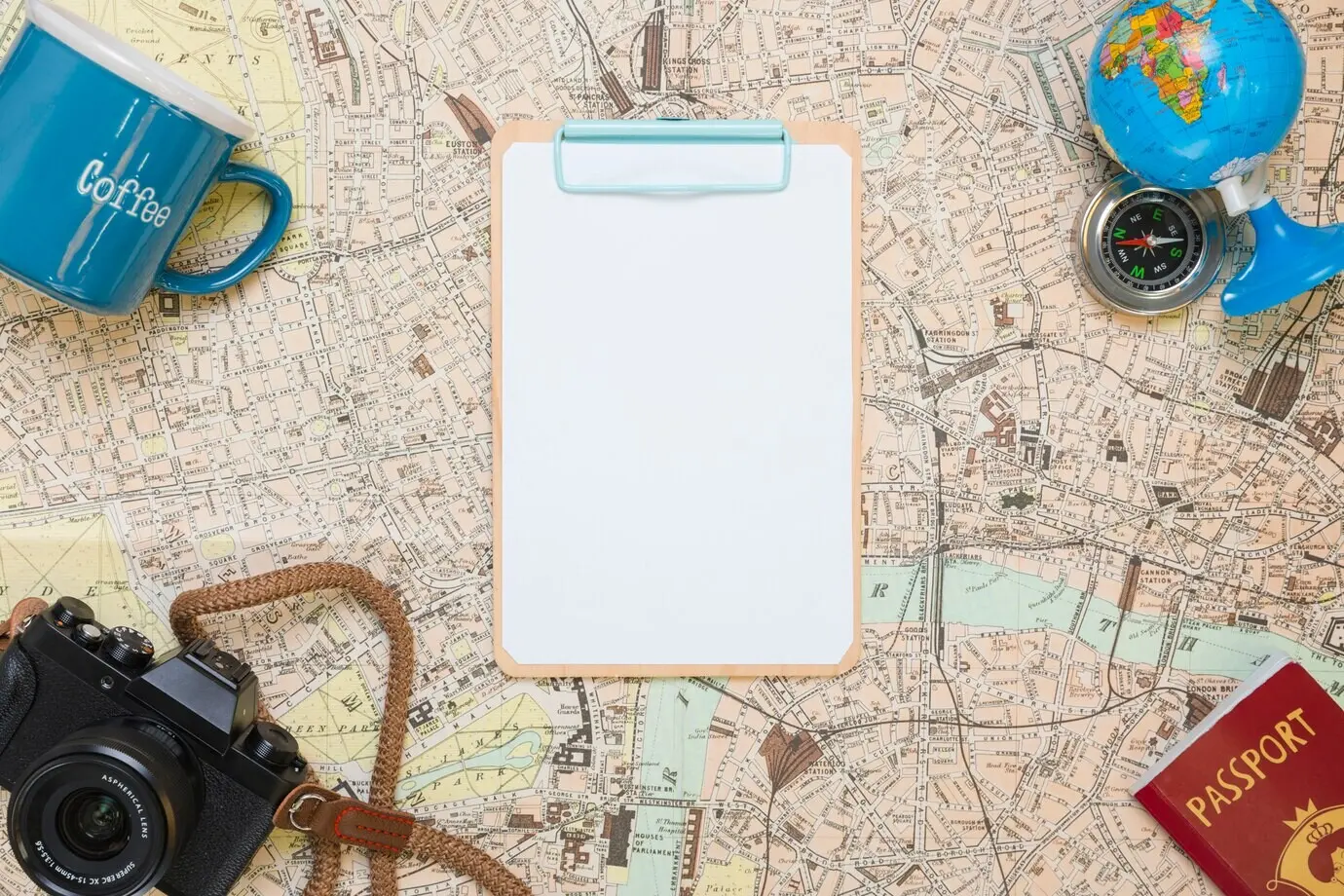Ordner auf einer Landkarte, umgeben von Reisegegenständen.